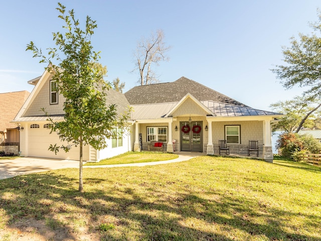 view of front of house featuring a porch, a garage, french doors, and a front lawn