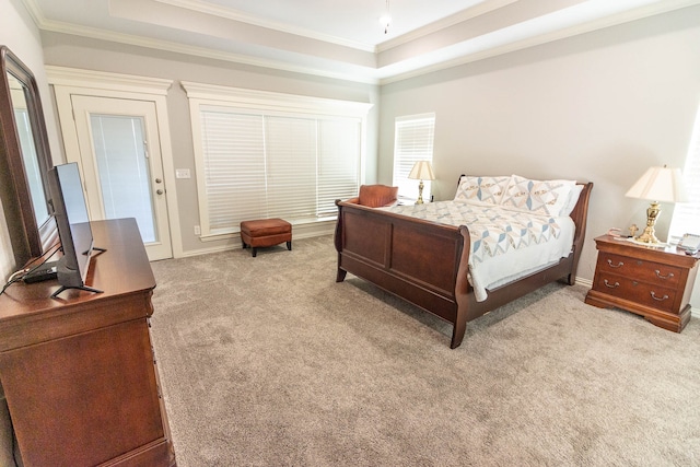 bedroom featuring light colored carpet, a tray ceiling, and ornamental molding