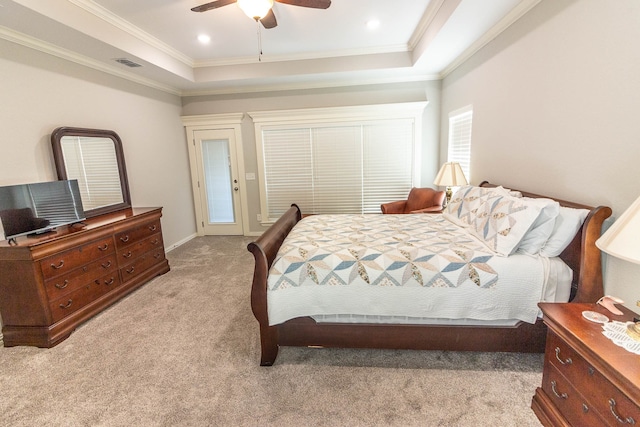 carpeted bedroom with ceiling fan, crown molding, and a tray ceiling