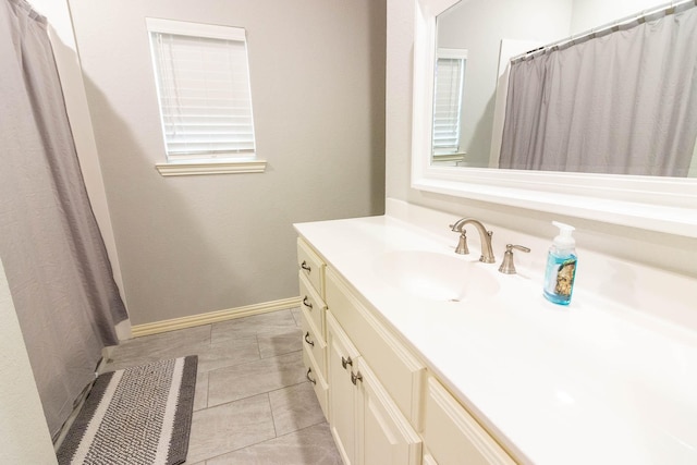 full bathroom featuring tile patterned floors, baseboards, and vanity