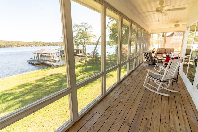 sunroom with a water view and ceiling fan