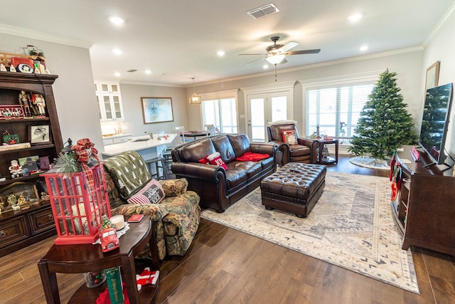 living room featuring dark hardwood / wood-style flooring, plenty of natural light, and crown molding