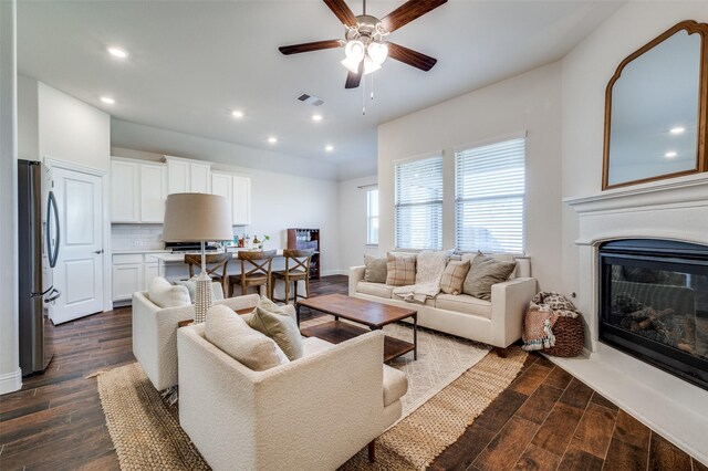 living room with ceiling fan and dark wood-type flooring