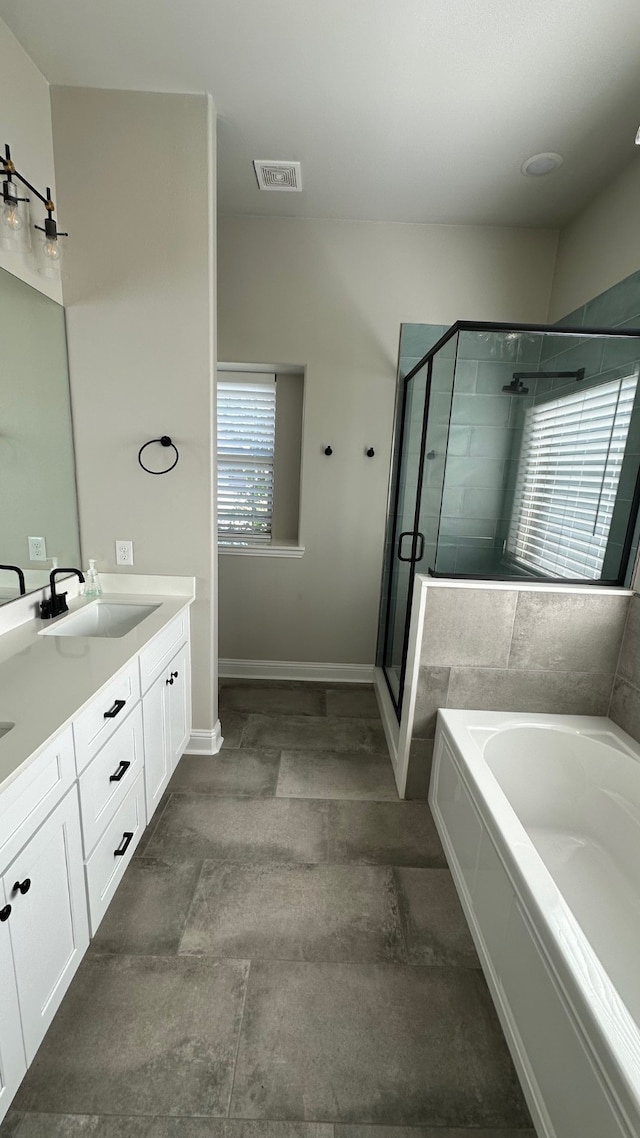 bathroom featuring vanity, shower with separate bathtub, and a wealth of natural light