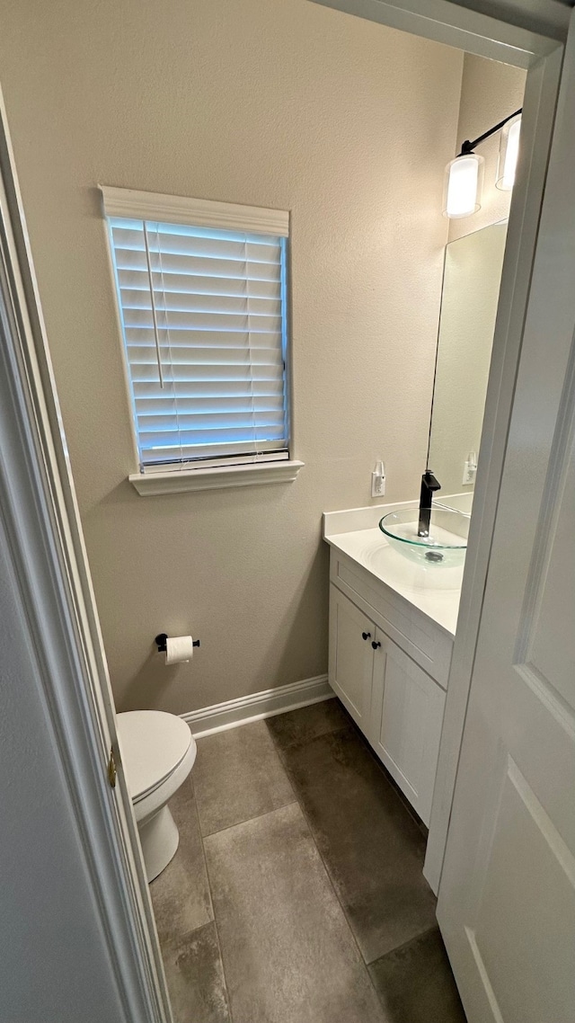 bathroom featuring tile patterned floors, vanity, and toilet