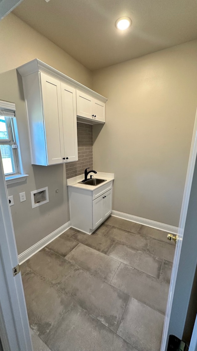 washroom featuring electric dryer hookup, cabinets, sink, and washer hookup