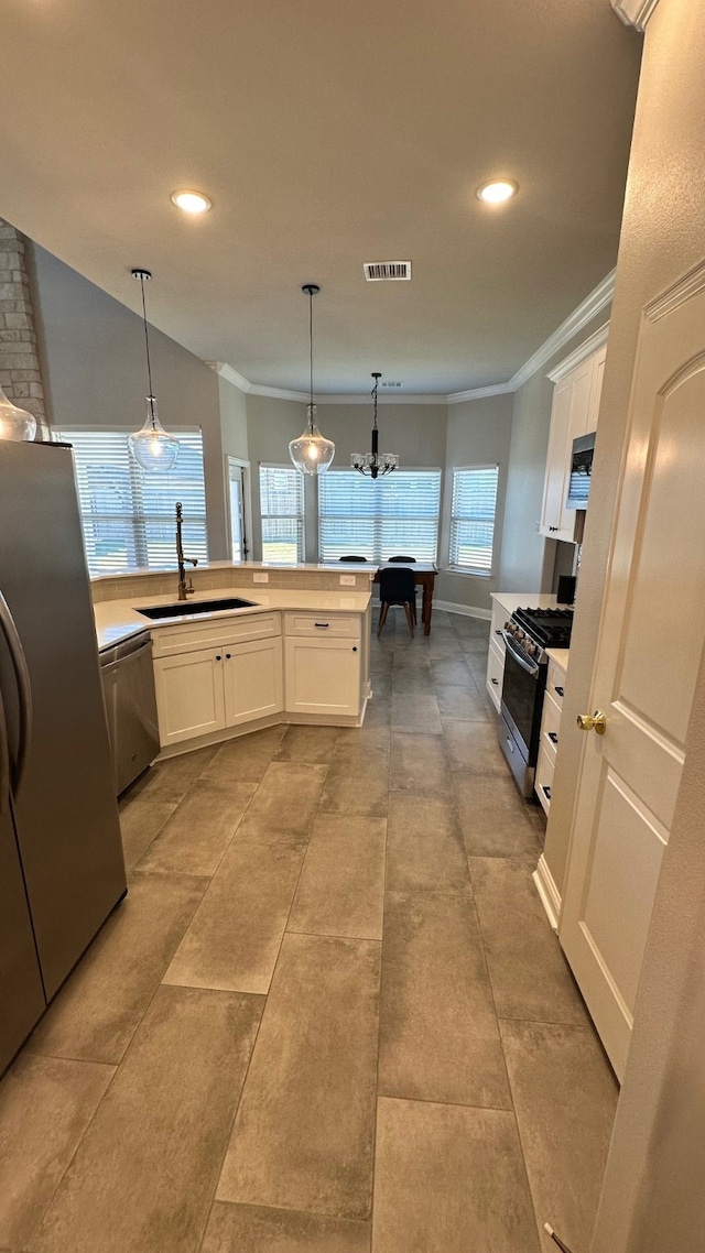 kitchen with stainless steel appliances, white cabinetry, a healthy amount of sunlight, and sink