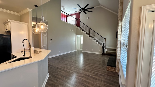 kitchen with black refrigerator, dark wood-type flooring, decorative light fixtures, high vaulted ceiling, and white cabinetry