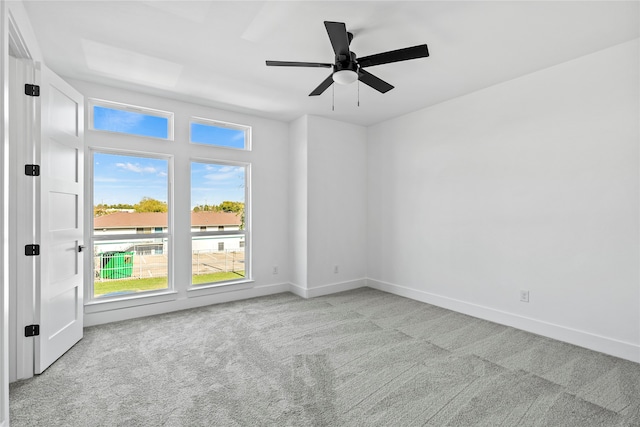 carpeted spare room featuring ceiling fan