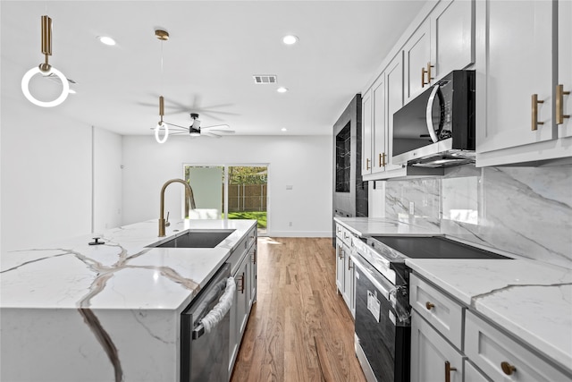 kitchen with ceiling fan, sink, stainless steel appliances, light hardwood / wood-style floors, and pendant lighting