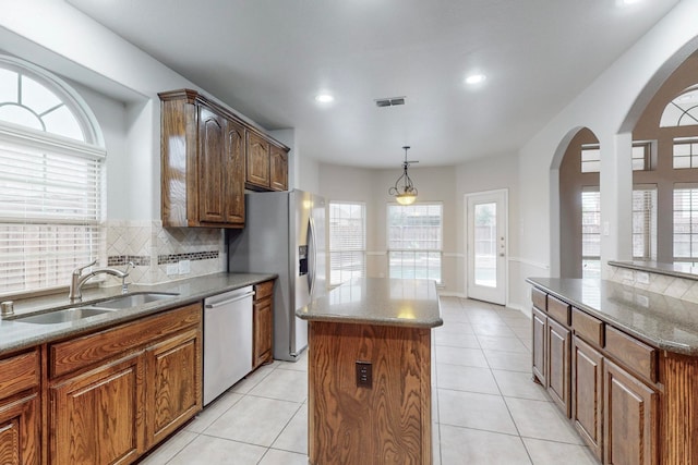 kitchen with tasteful backsplash, sink, a kitchen island, and stainless steel appliances