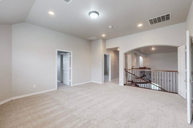 carpeted empty room with lofted ceiling