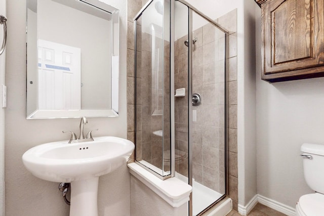 bathroom featuring toilet and an enclosed shower