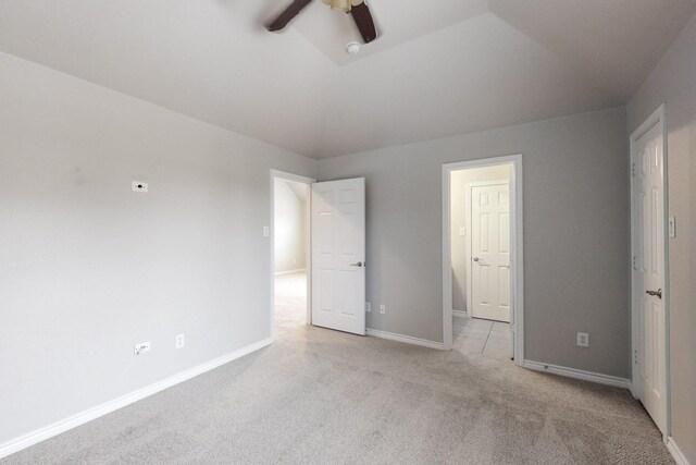 unfurnished bedroom with ceiling fan, light colored carpet, and lofted ceiling