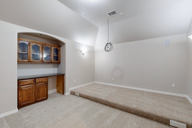 interior space featuring light colored carpet and lofted ceiling