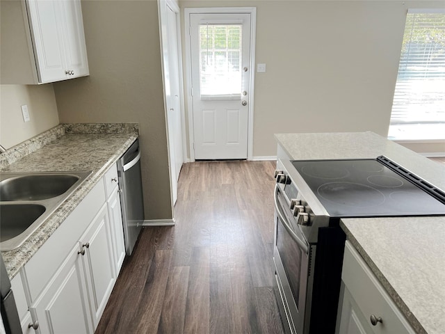 kitchen featuring dark hardwood / wood-style floors, white cabinetry, stainless steel appliances, and a wealth of natural light