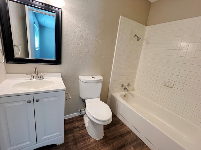 full bathroom with hardwood / wood-style flooring, vanity, toilet, and tiled shower / bath