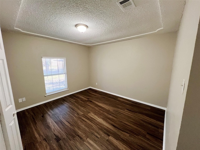 spare room featuring wood-type flooring and a textured ceiling