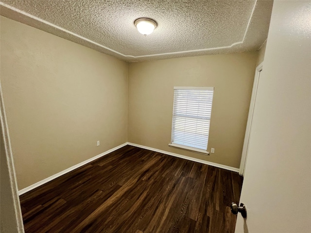 empty room featuring a textured ceiling and dark hardwood / wood-style flooring