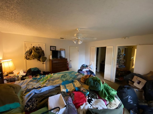 bedroom with ceiling fan and a textured ceiling