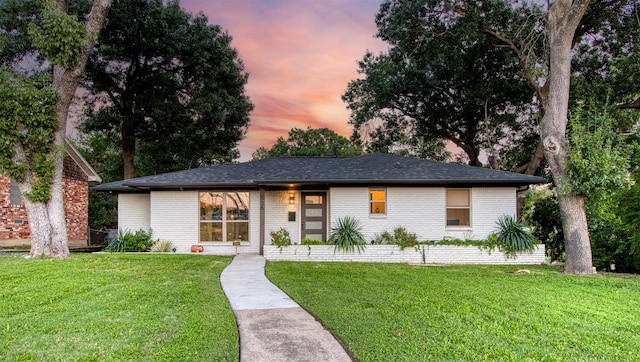 ranch-style home with a lawn