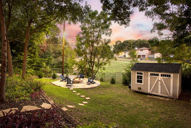 yard at dusk with a patio, a shed, and a fire pit