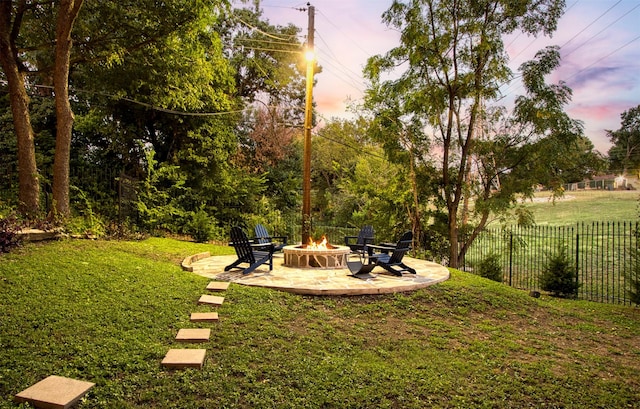 yard at dusk featuring a patio and an outdoor fire pit