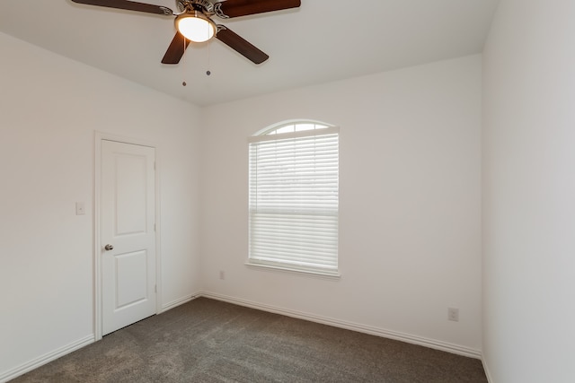 unfurnished room featuring dark colored carpet and ceiling fan