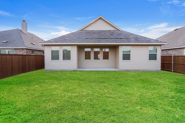 back of property with a patio area and a yard