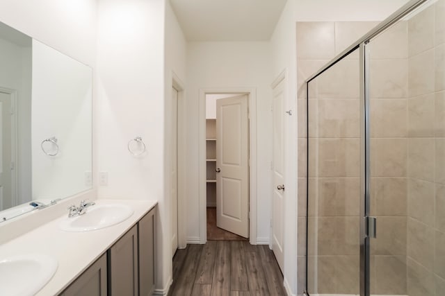 bathroom featuring vanity, wood-type flooring, and a shower with shower door