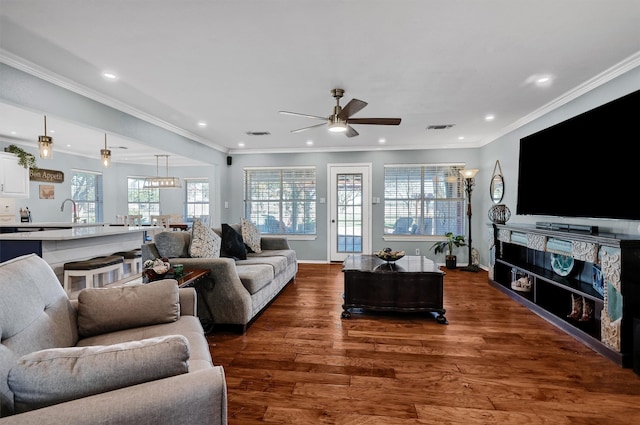 living room with a fireplace, dark hardwood / wood-style floors, ceiling fan, and ornamental molding