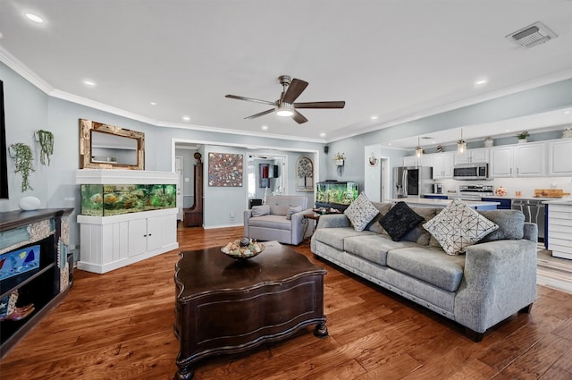 living room featuring hardwood / wood-style floors, ceiling fan, and ornamental molding