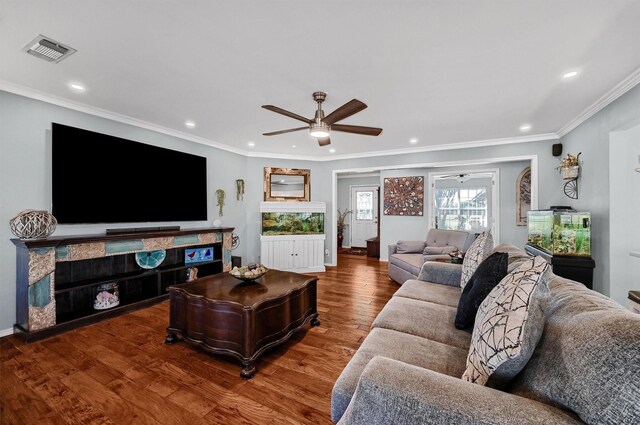 living room with hardwood / wood-style flooring, ceiling fan, and crown molding