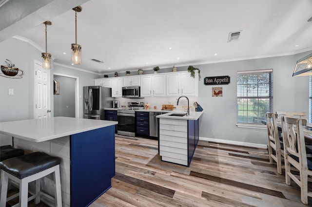 239 W Line Rd, Whitesboro, TX 76273 - kitchen featuring stainless steel appliances, a sink, crown molding, a breakfast bar area, and light wood finished floors
