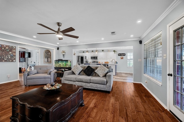 living room featuring dark hardwood / wood-style flooring, ceiling fan, and crown molding