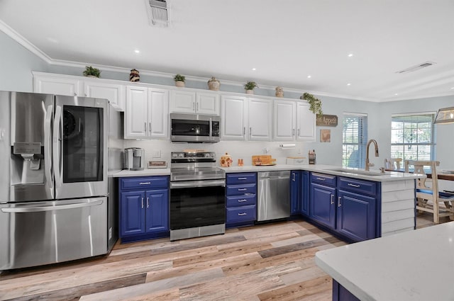 239 W Line Rd, Whitesboro, TX 76273 - kitchen featuring stainless steel appliances, blue cabinetry, a peninsula, white cabinets, and light wood-type flooring