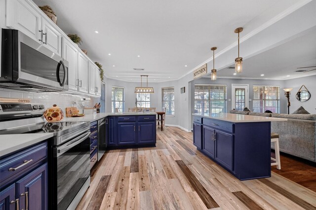 kitchen featuring blue cabinetry, a healthy amount of sunlight, white cabinetry, and stainless steel appliances