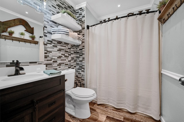 bathroom with tasteful backsplash, crown molding, wood-type flooring, toilet, and vanity