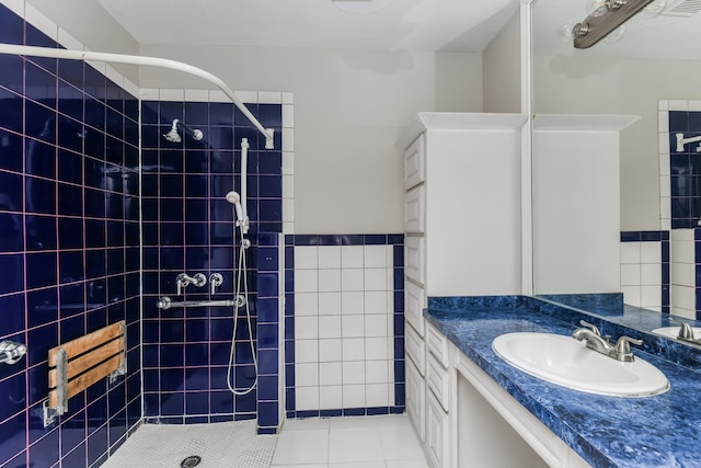 bathroom with tile patterned floors, vanity, and tiled shower