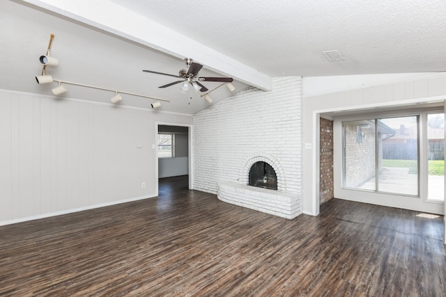 unfurnished living room with dark wood-type flooring, a brick fireplace, vaulted ceiling with beams, ceiling fan, and a textured ceiling