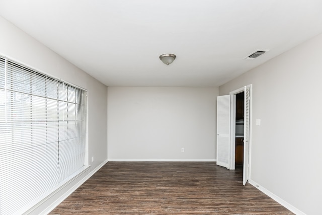 unfurnished room with dark hardwood / wood-style flooring