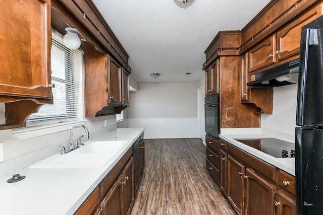 kitchen featuring black appliances, sink, and dark wood-type flooring