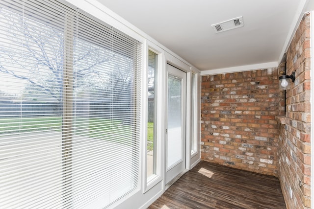 entryway featuring dark hardwood / wood-style floors and brick wall