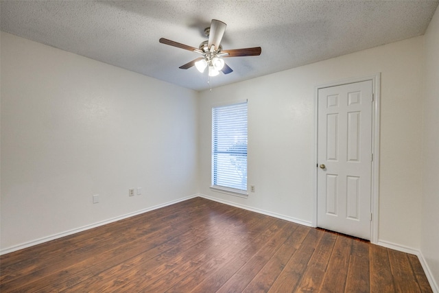 spare room featuring ceiling fan, dark hardwood / wood-style floors, and a textured ceiling