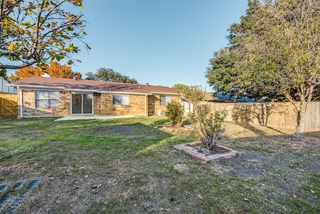 rear view of property featuring a patio area and a lawn