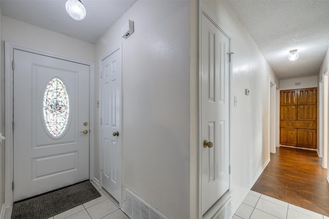 foyer with light hardwood / wood-style flooring and a textured ceiling