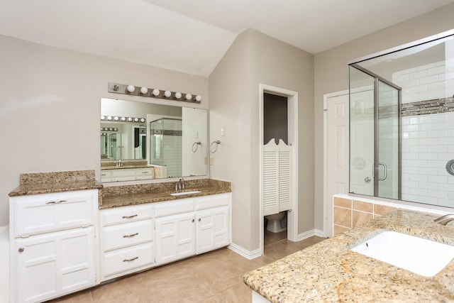 bathroom featuring tile patterned flooring, vanity, and a shower with door