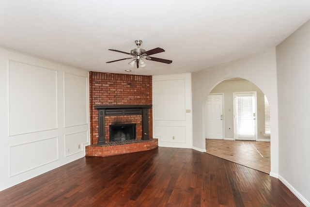 unfurnished living room featuring hardwood / wood-style floors, ceiling fan, and a fireplace