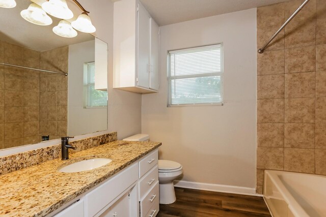 full bathroom featuring wood-type flooring, vanity, toilet, and a healthy amount of sunlight