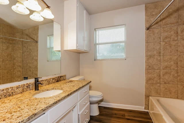 full bathroom featuring tiled shower / bath combo, wood-type flooring, vanity, and toilet